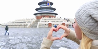 北京天坛，女人做心形手指架