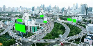 鸟瞰图泰国城市建筑和繁忙的交通道路与绿色屏幕广告广告牌