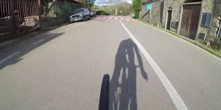 在托斯卡纳乡村骑自行车。从后面看