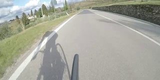 在托斯卡纳乡村骑自行车。从后面看