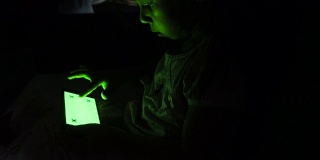 女孩在沙发上用绿色屏幕的智能手机