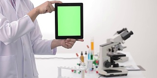 科学家和生物实验室用绿色屏幕的数字平板电脑做实验。4 k