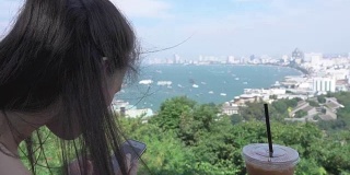 亚洲美丽的女孩使用智能手机海景