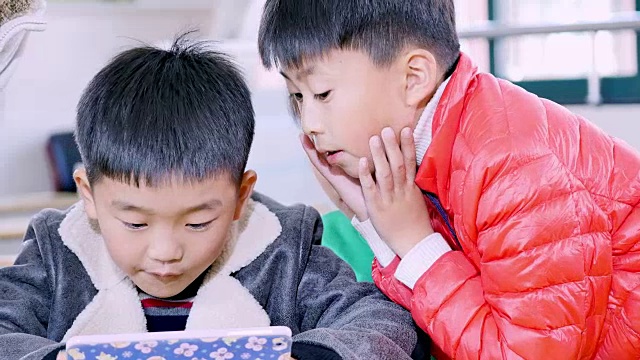 小学生在教室里用平板电脑学习。