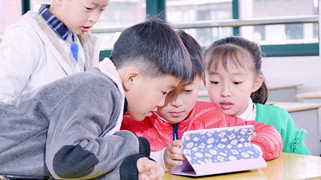 小学生在教室里用平板电脑学习。