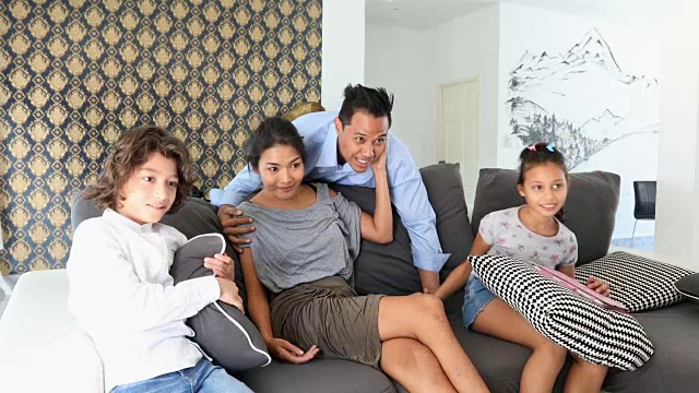 亚裔父亲回家和家人一起看电视