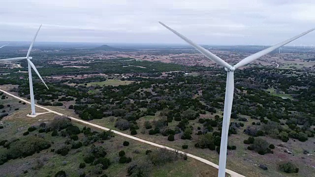 一个多云有风的一天在风力涡轮机农场在得克萨斯州中部，美国无人机的涡轮机侧pan的视图线
