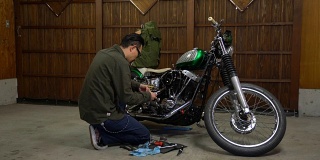 修理和维护他的定制摩托车在他的车库