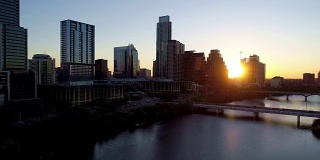 阳光灿烂，随着太阳升起在摩天大楼之间沿着奥斯丁城市天际线鸟瞰图在奥斯丁德克萨斯州在日出剪影的城市