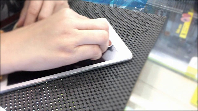 女性手部清洁屏幕的数字平板电脑