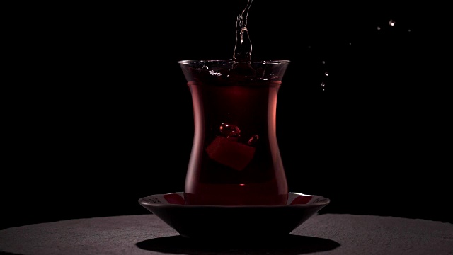 将方糖倒入一杯传统土耳其茶中。