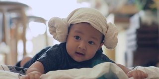 男婴(6-9个月)戴着帽子在垫子上爬行