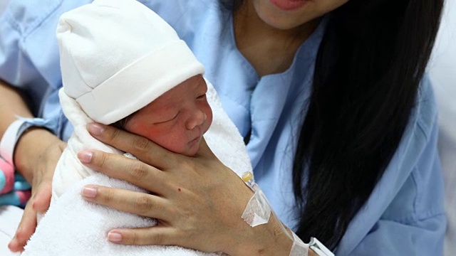 母亲用奶瓶喂新生儿