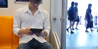年轻人在火车上使用平板电脑