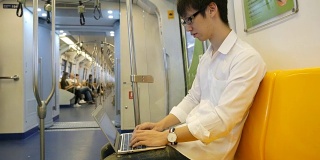 年轻人在火车上使用手提电脑