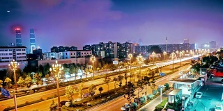 中国昆明夜晚的柏油路和现代城市天际线
