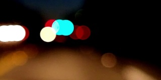 夜间在城市街道上开车的个人视角。