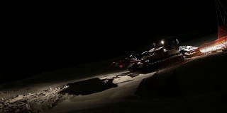 使滑雪场平整的机器在夜间工作。