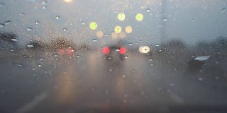 在黄昏下着雨的高速公路上开车，聚焦在车架上。