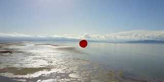 孤独的红色气球高高地漂浮在大盐湖上