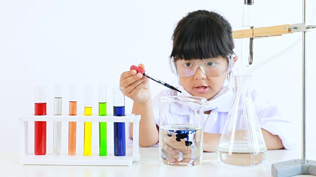 亚洲儿童玩科学家与彩色实验室管