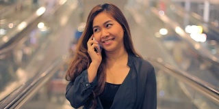 微笑的年轻亚洲女商人在她的手机