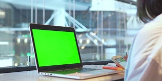 在购物中心使用绿色屏幕的智能手机和笔记本电脑