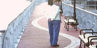 一位老人在城市海滨散步
