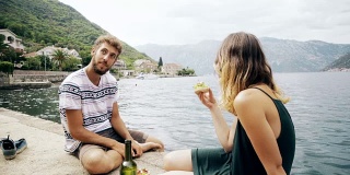 一对年轻夫妇在海边吃午餐