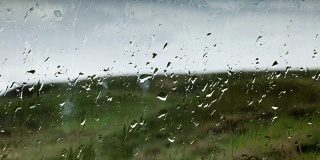 在青山背景的玻璃上，有几滴雨点