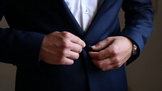 新郎在婚礼前扣上他的蓝色夹克视频素材模板下载