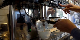 陌生的女服务员正在用机器煮新鲜咖啡