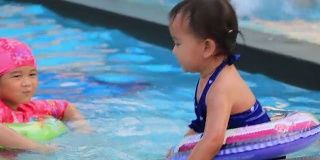 小女孩在游泳池里游泳。