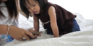 亚洲母亲和孩子使用智能手机