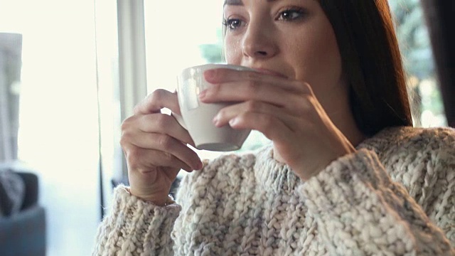 年轻美丽的女人享受着一杯咖啡。