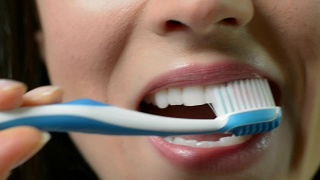 女人用手动牙刷刷牙的特写视频素材模板下载