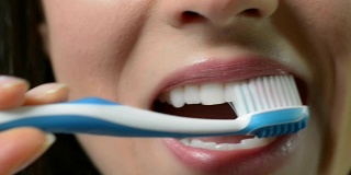 女人用手动牙刷刷牙的特写