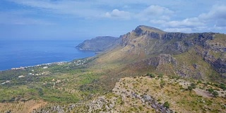 鸟瞰图的岩石海岸线和海岸平原附近的Cap Farrutx和村庄Betlem在巴利阿里群岛马略卡/西班牙北部海岸