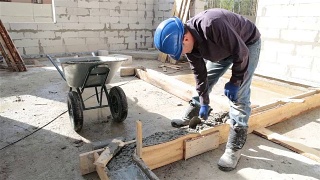 工人用泥铲将混凝土放入模板中。视频素材模板下载