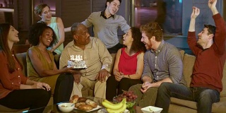 一位年长的黑人男子正在和他的家人和朋友庆祝他的生日