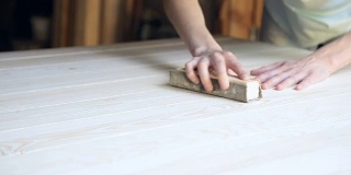 工匠对未来桌子的木质表面进行加工。