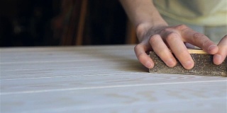 工匠对未来桌子的木质表面进行加工。