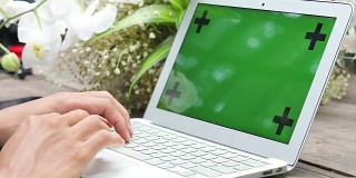 商人正用绿色屏幕的笔记本电脑，