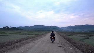 在农村的土地上骑摩托车视频素材模板下载