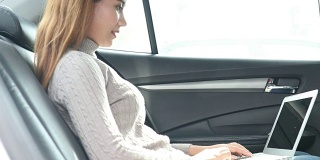 女性在汽车的副驾驶座上使用智能手机