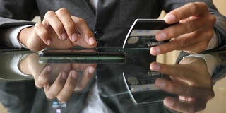 商人正在网上购物，智能手机将信用卡信息输入手机，慢动作