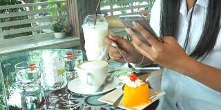 一个女人的手在咖啡店用智能手机