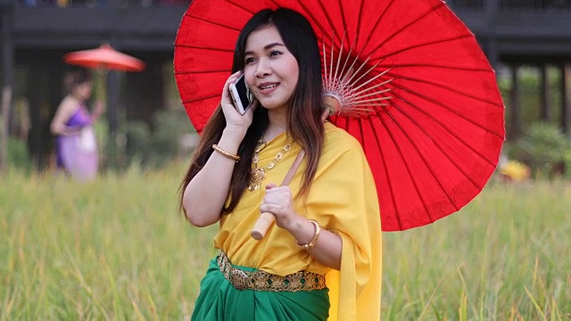 泰国妇女穿着传统风格拿手机