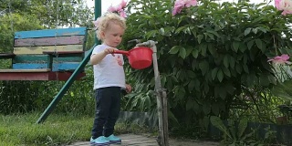 小女孩在玩盛水的勺子。