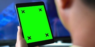 过肩拍摄使用数码平板电脑，绿色屏幕